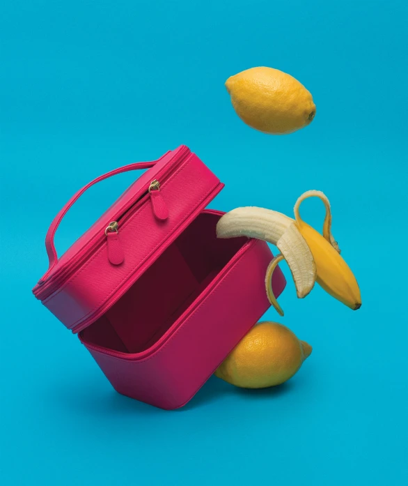 a pink and pink suitcase and some lemons