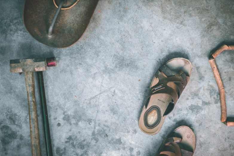 an old shoe and some tools on a cement ground