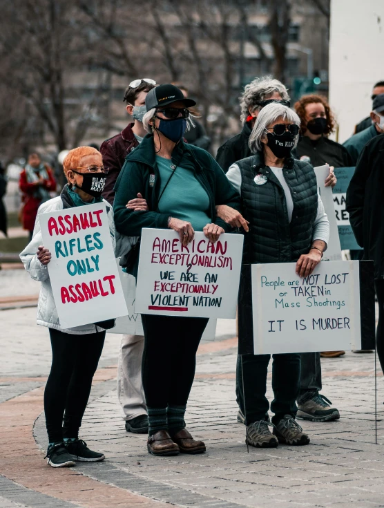 several people are holding signs outside in a protest