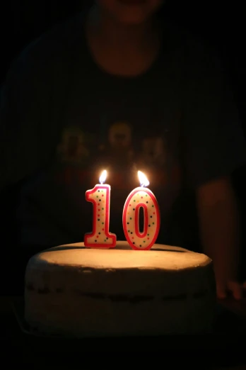 a birthday cake with lit candles and the number ten