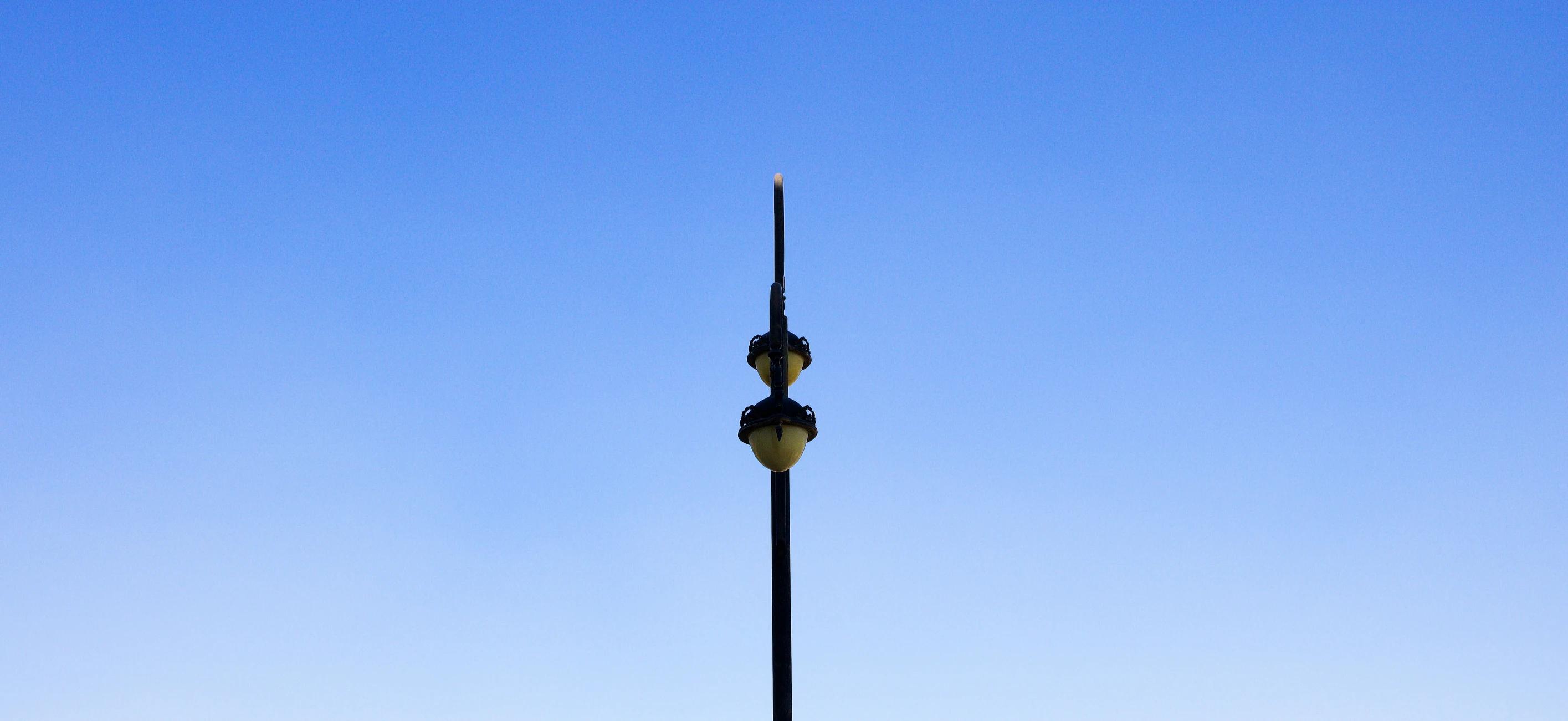 an elegant lamp post in front of blue sky