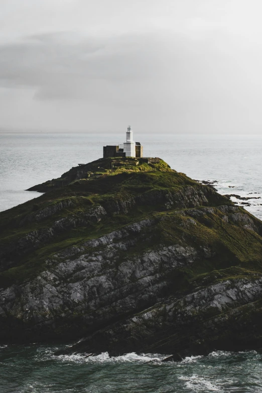 two white lighthouses are on top of a small island