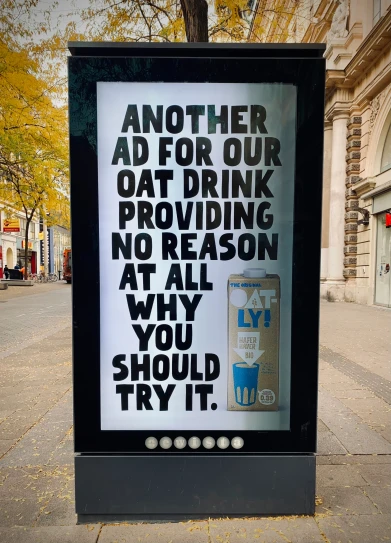 a sign posted to the side of a road that says another ad for our oat drink providing no reason