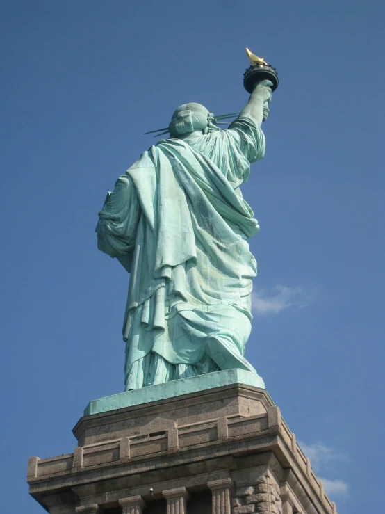 the statue of liberty is against a blue sky