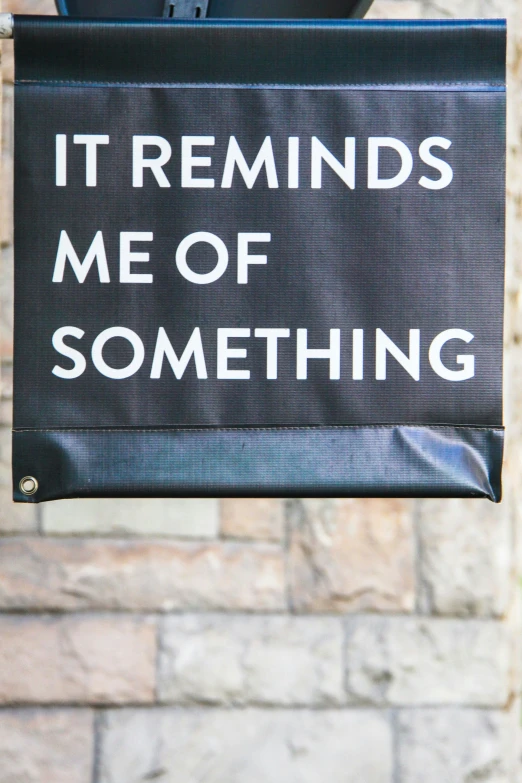 a sign is hung in front of a brick wall