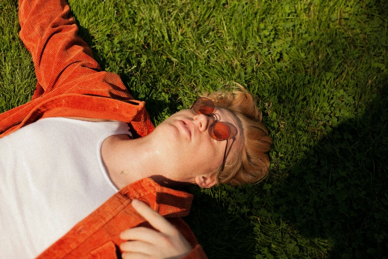 a person laying on the grass with sunglasses and head tilted backwards