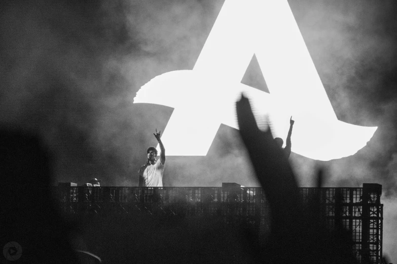 people on stage at a concert and one holding up a large letter