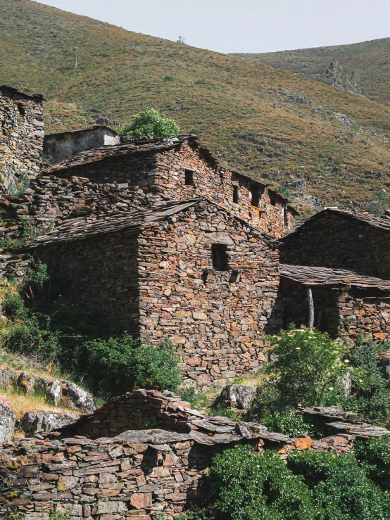 a ruined, old house sitting in the mountains