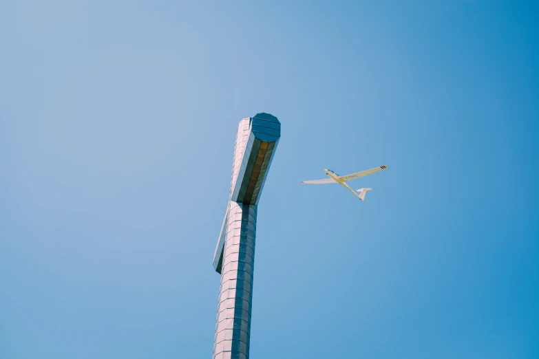 a plane flying over a large blue sign