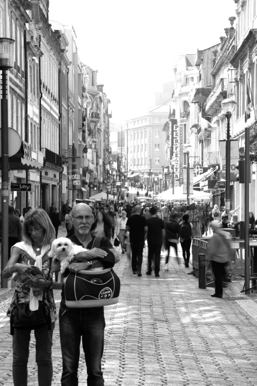 an older woman holding a baby and a dog