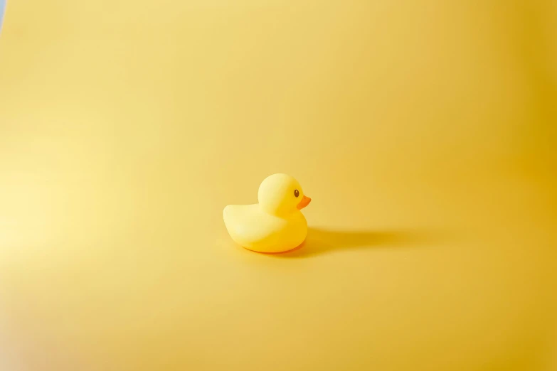 a rubber duck is on a yellow surface