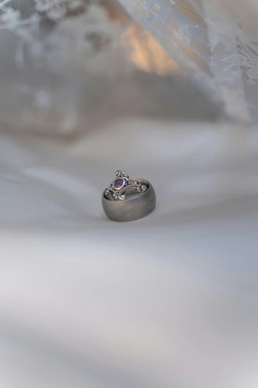 two wedding rings with diamond accents sitting on the surface