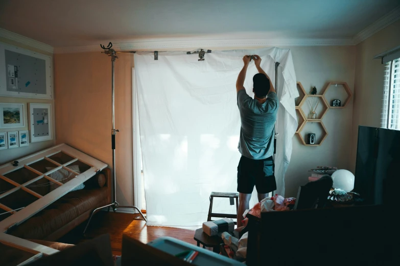 a person standing in a room with a curtain open