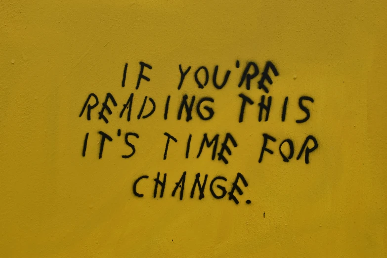a message is on the side of a yellow building