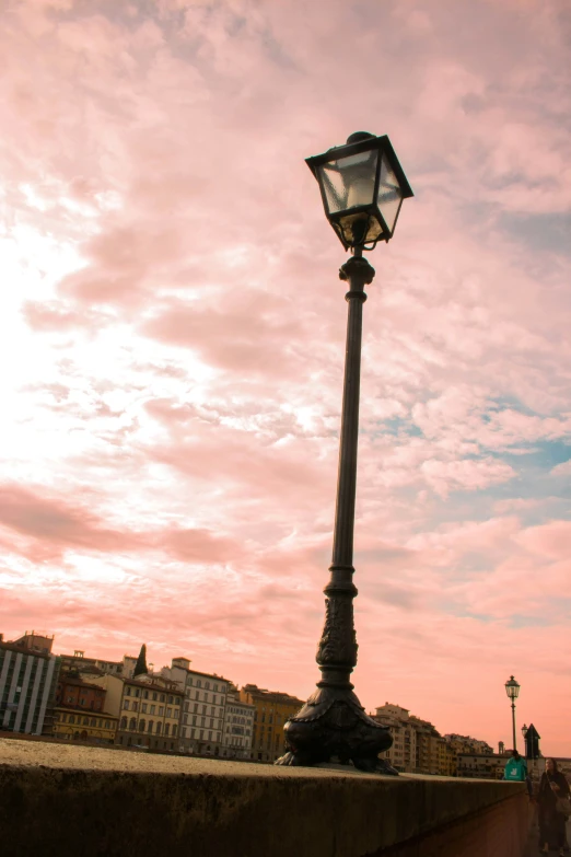 an old - fashioned street lamp on a bridge with the sky in the background