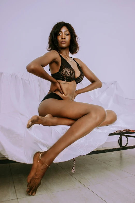 a young lady posing on her bed in an open underwear