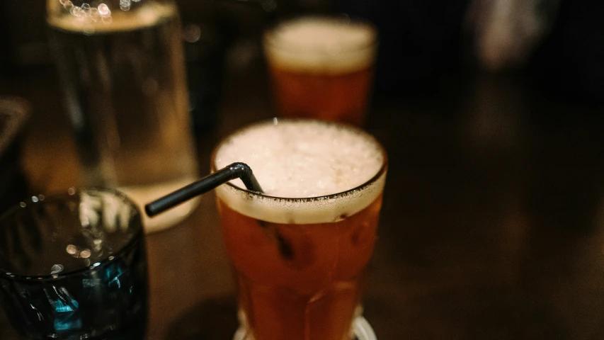 a glass of beer sitting on top of a table