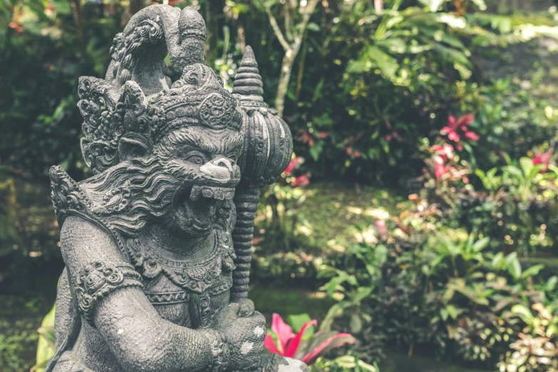 an intricate stone statue of an elephant sitting in the middle of a garden