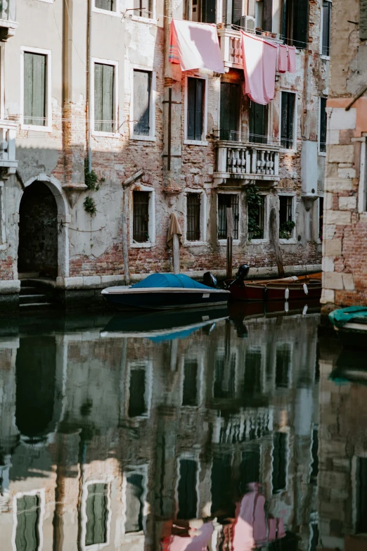 a boat is anchored in the water near two buildings