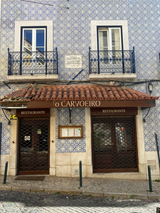 a building with two brown doors and red tiled roof