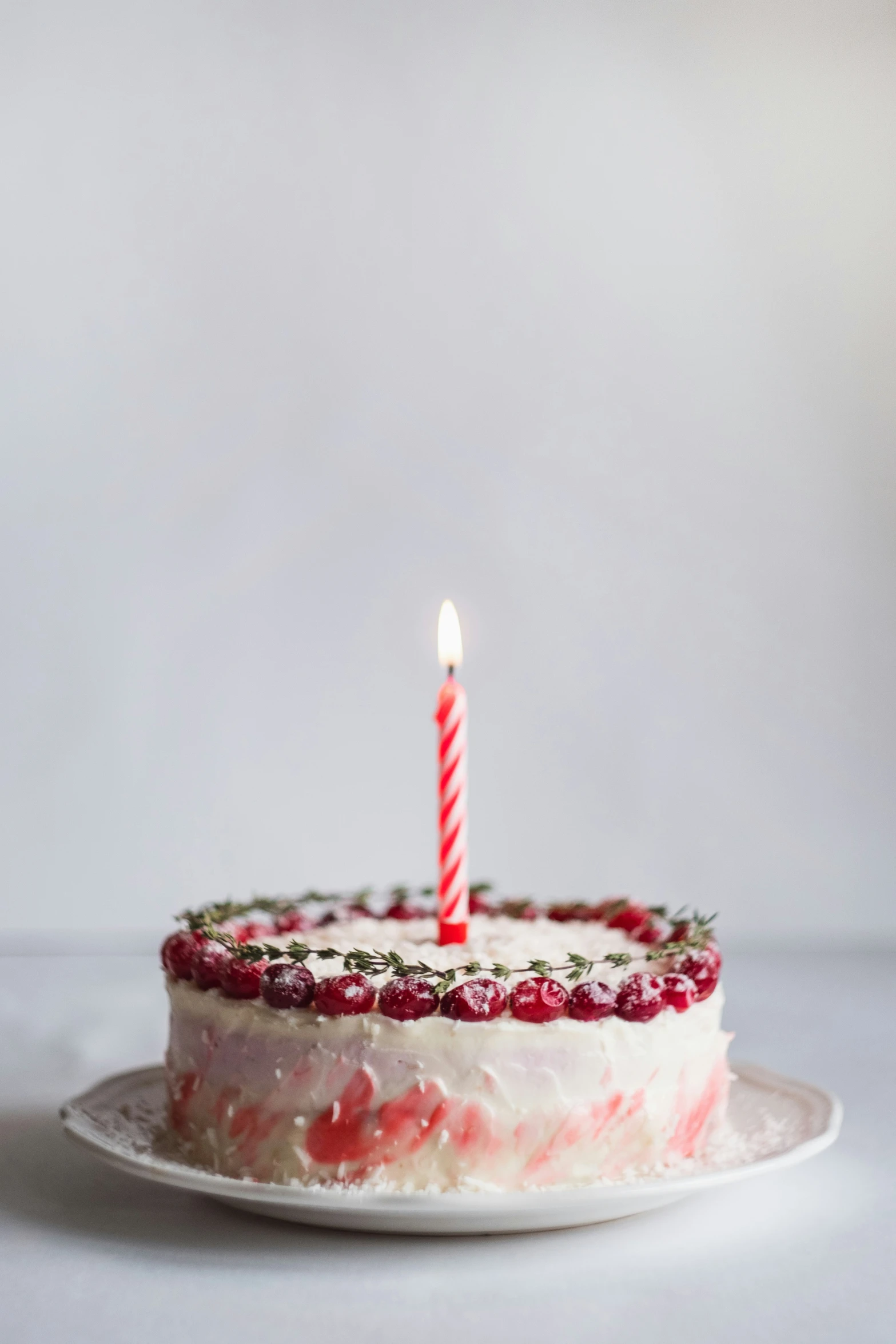a birthday cake with a lit candle on a plate