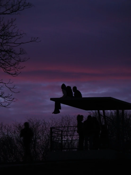 a couple of people on a platform over looking a twilight sky