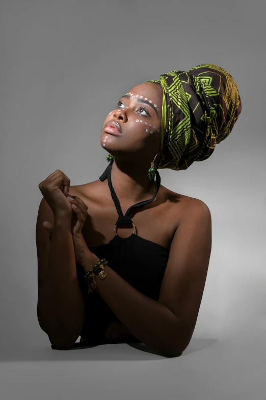 a black woman wearing a turban looks to the side