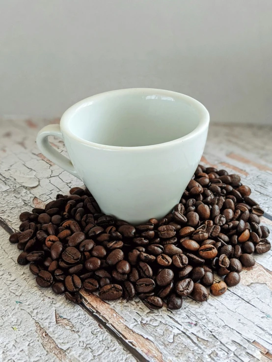 there are coffee beans and a cup on the table