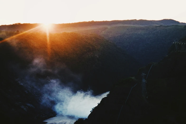 a scenic view of the top of a mountain with mist rising up from its base