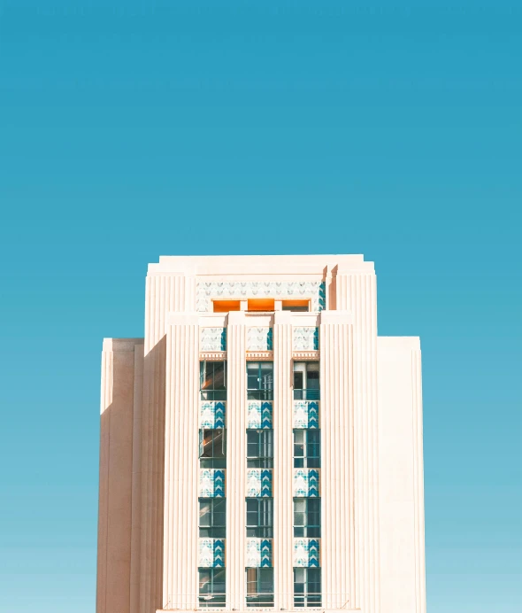 a building with columns and windows is shown against a blue sky