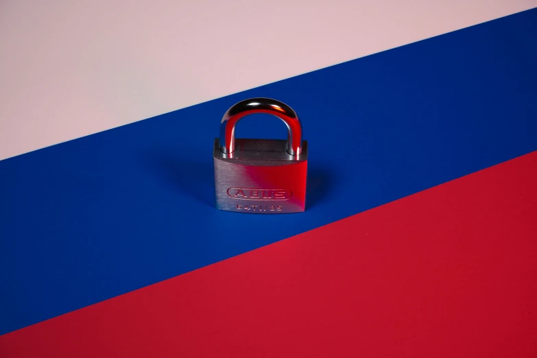 an open metal padlock on the colorful stripes