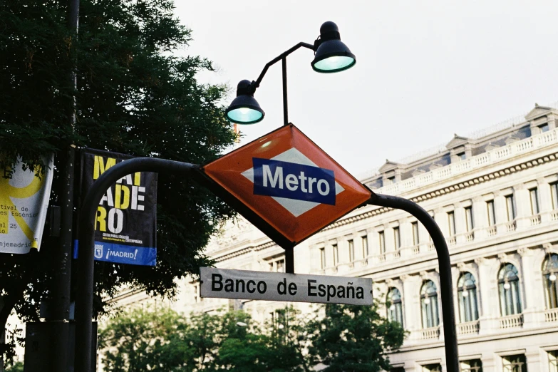 an electronic sign for a metro station stands on a pole in the city