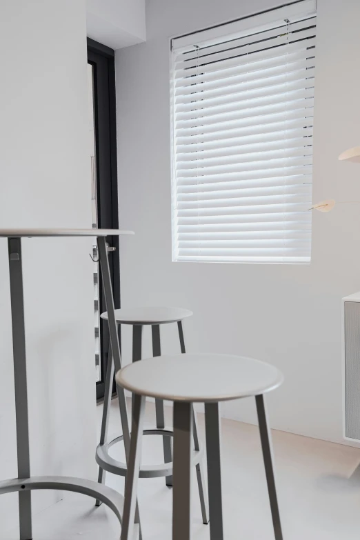 three stools sitting beside a table with a lamp