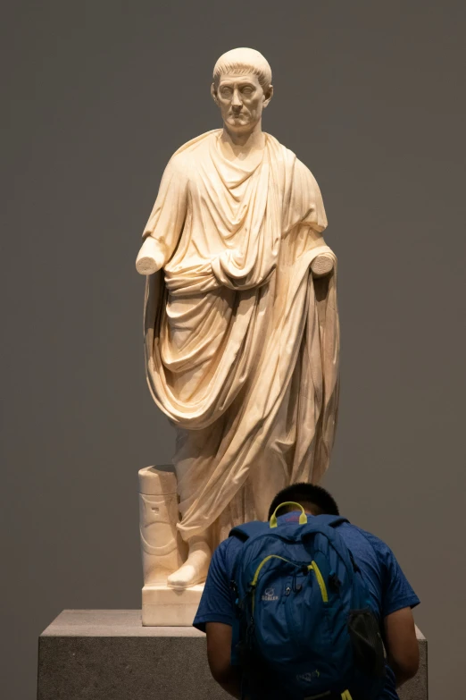 a man is taking a po in front of a statue