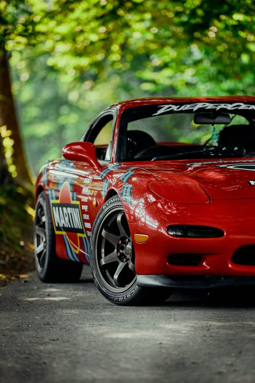 a red sports car with its hood open parked on the road