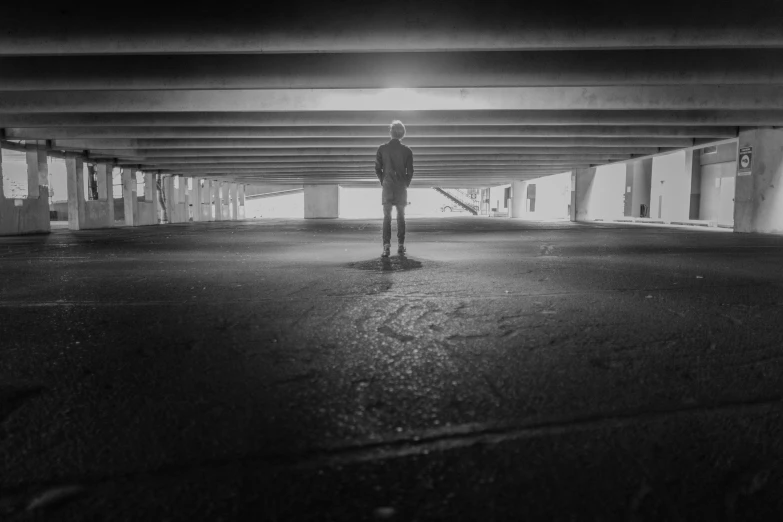 the man stands alone in an empty parking garage