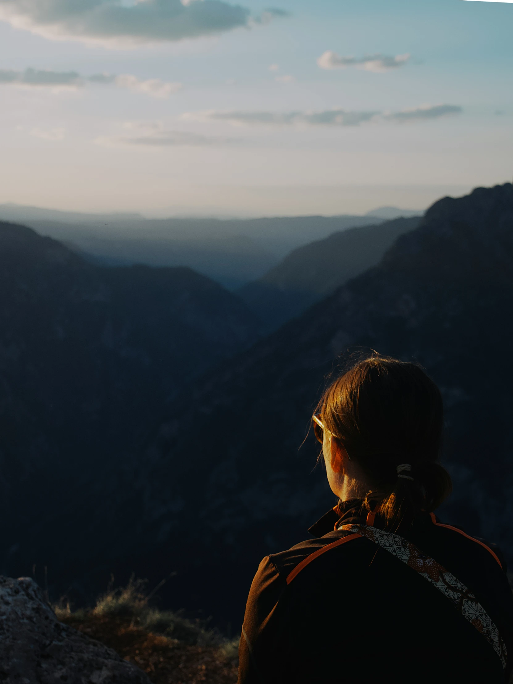 a woman looking out over mountains with her head back