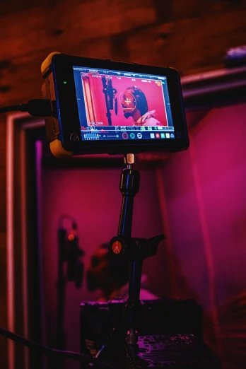 a cellphone on a tripod with pink light