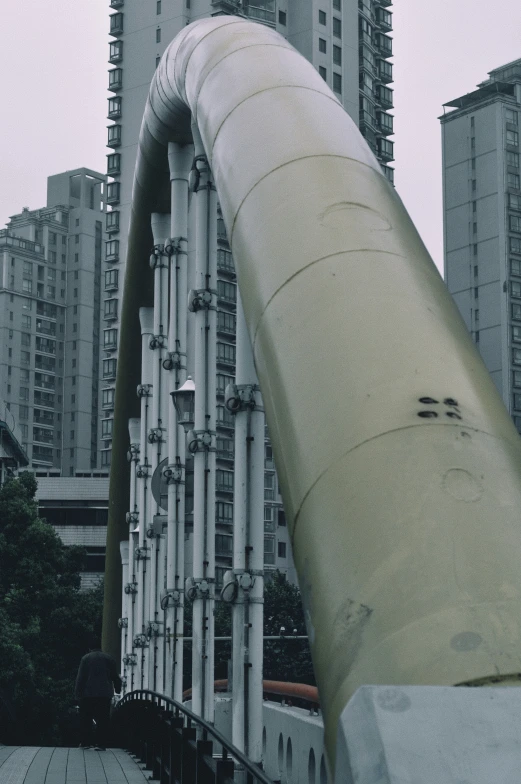 view looking down on a large industrial pipe and high rise buildings