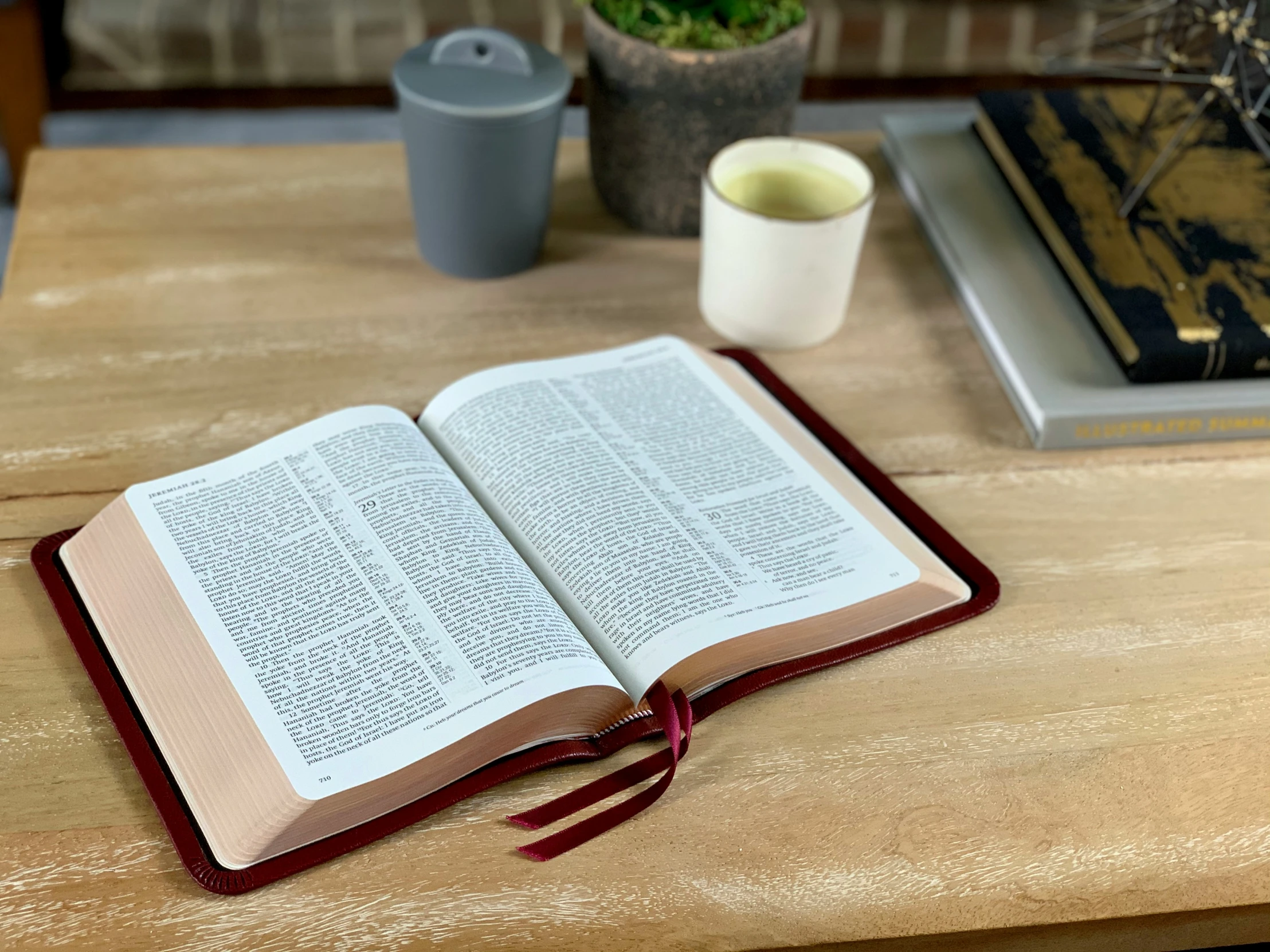 an open book and two cups on a table