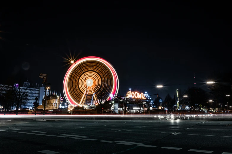 a ferris wheel and lights are shown at night