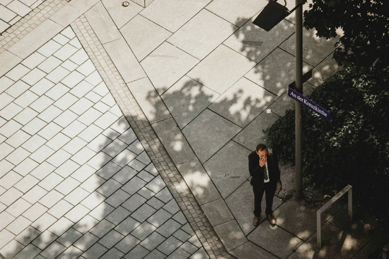 two men walking down the sidewalk on a sunny day