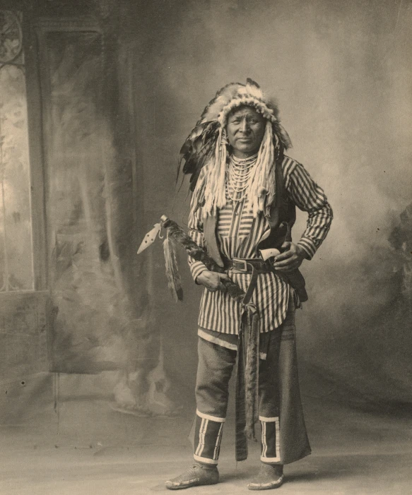 an indian man in an elaborate head dress and a large sword