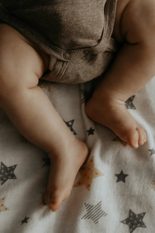 a baby lying down on a white and blue blanket