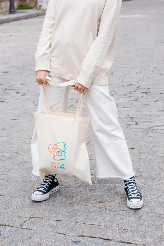 a person holding a bag while standing on a street