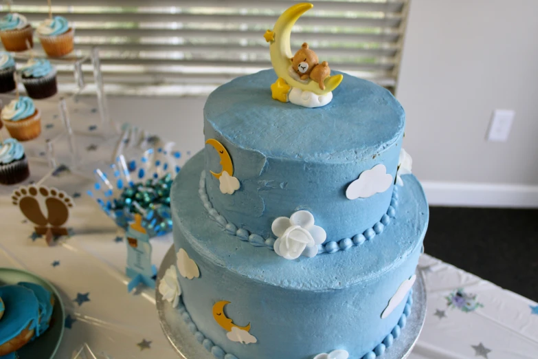 a small blue cake with white and yellow decorations
