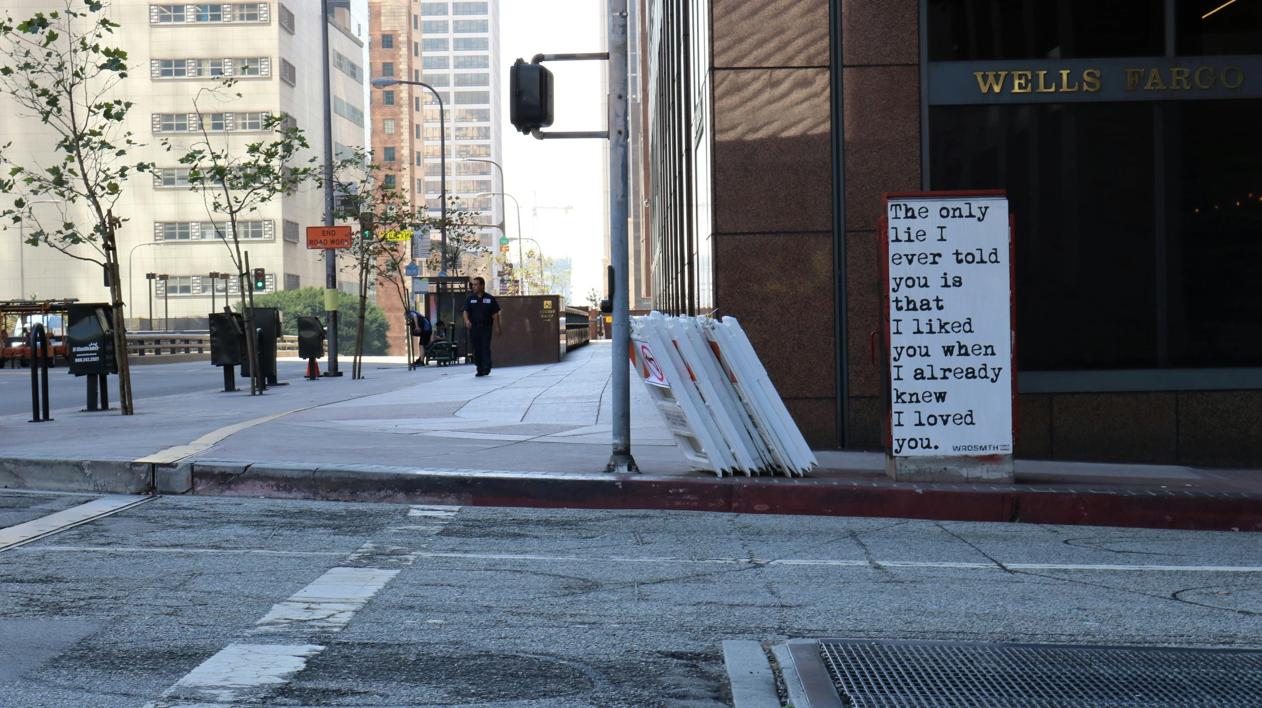 a sidewalk next to tall buildings near a city street