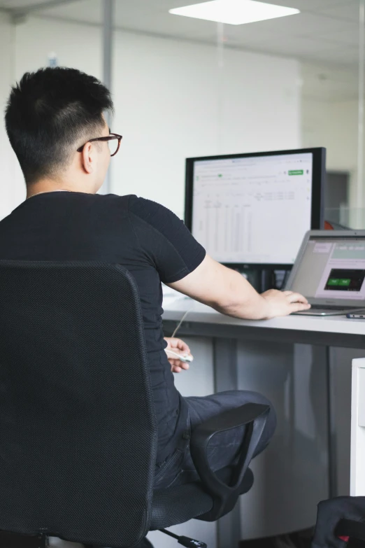 a man sitting at a table in front of a computer