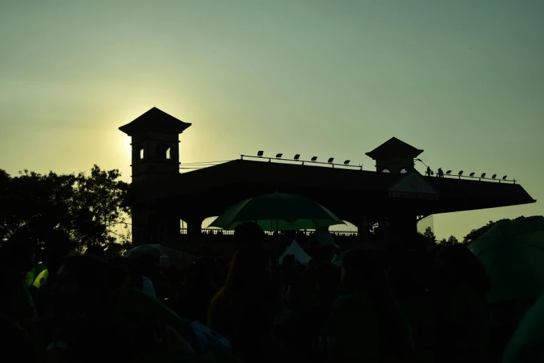 silhouetted people with an umbrella and a flock of birds sitting on roof