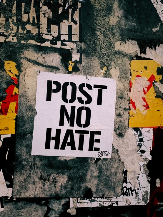 a group of people walk down a street with street signs on the wall